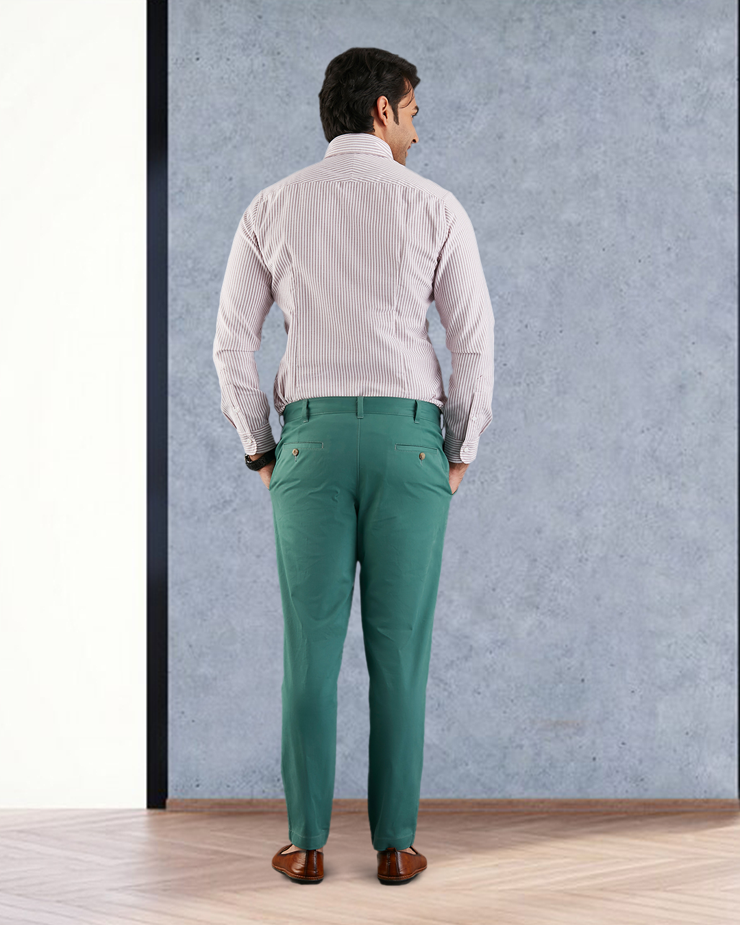 Model back view wearing custom Genoa Chino pants for men by Luxire in fern green hands together